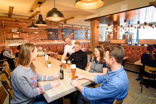 a group of people sitting around a table in a restaurant at Biohotel Garmischer Hof in Garmisch-Partenkirchen