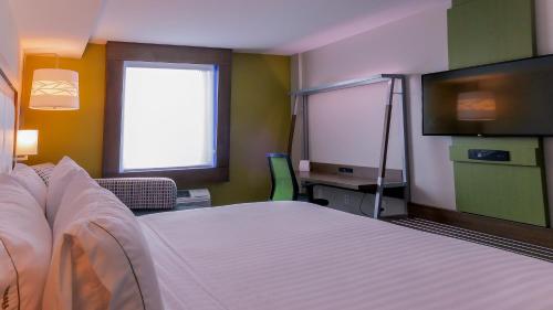 a hotel room with a bed and a flat screen tv at Holiday Inn Express & Suites Miami Airport East by IHG in Miami