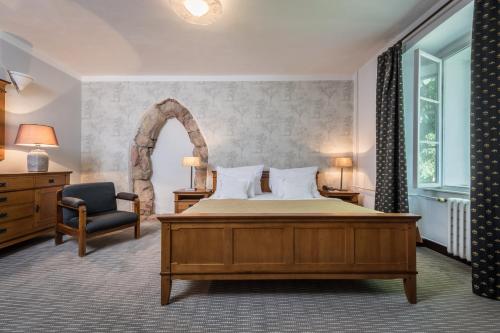 a bedroom with a large bed and a chair at Monastery Garden Prague in Prague