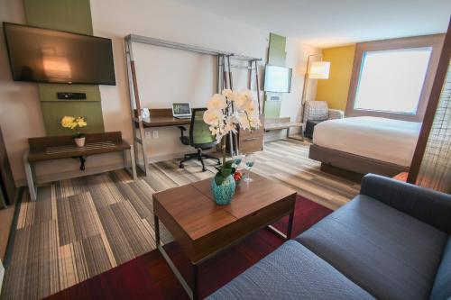 a hotel room with a bed and a living room at Holiday Inn Express & Suites Miami Airport East by IHG in Miami