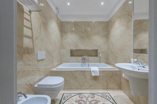 a bathroom with a tub and a toilet and a sink at Monastery Garden Prague in Prague