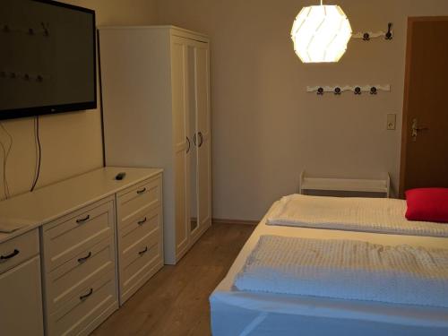 a bedroom with a bed and a flat screen tv at Asiatisches Landhaus in Braunsbedra