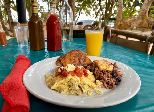 Little Corn Island Beach and Bungalow في جزيرة ليتل كورن: طبق من الطعام على طاولة مع طبق من الطعام