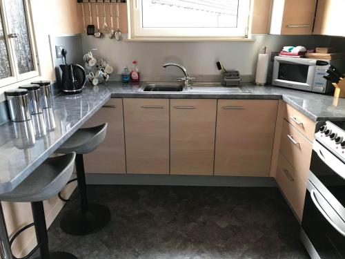 una cucina con lavandino e piano cottura forno superiore di Apartment 76 a Kirkwall