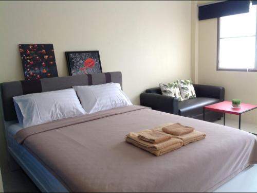 a bedroom with a bed with two towels on it at Phuket Town Budget House - Aircon Room #1 in Ban Lo Long