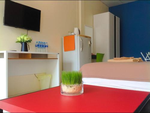 a room with a red table and a refrigerator at Phuket Town Budget House - Aircon Room #1 in Ban Lo Long