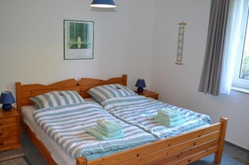 - une chambre avec un lit et 2 serviettes dans l'établissement Ferienwohnung im Rugstieg, à Wyk auf Föhr