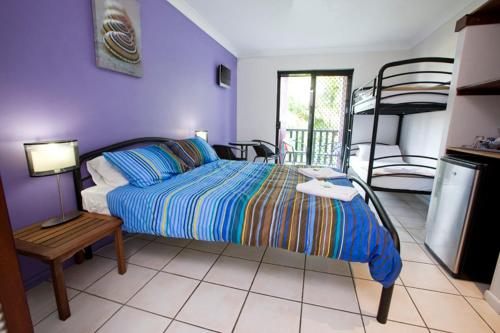 a bedroom with a bed and a bunk bed at Bohemia Resort Cairns in Cairns