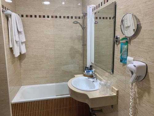 La salle de bains est pourvue d'un lavabo, d'une douche et d'une baignoire. dans l'établissement Hotel Europa Boutique Sevilla, à Séville