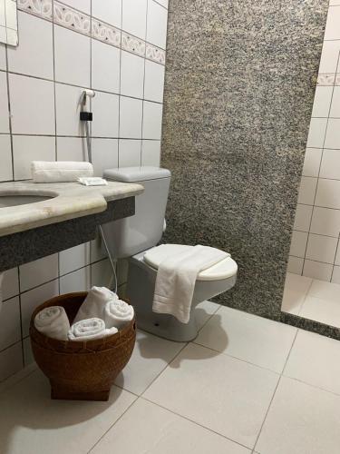 a bathroom with a toilet and a sink at Hotel Monte Pascoal Smart in Porto Seguro