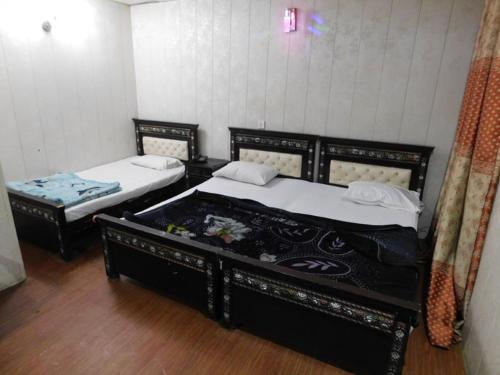 Shah Taj Hotel في لاهور: سريرين في غرفة بسريرين