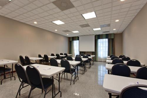 a conference room with tables and chairs and a screen at Holiday Inn Express Hotel & Suites Hermosa Beach by IHG in Hermosa Beach