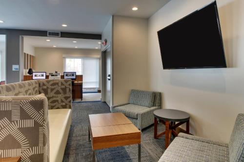a living room with chairs and a flat screen tv at Holiday Inn Express & Suites Ithaca by IHG in Ithaca