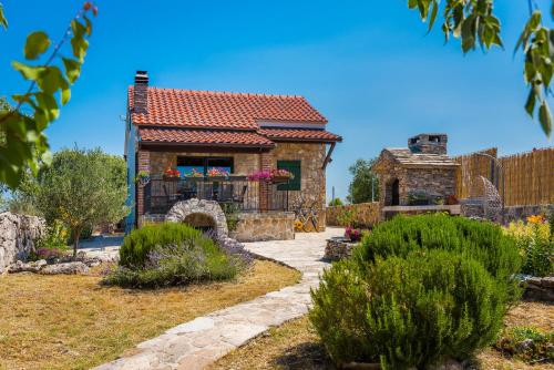 uma casa de pedra com uma cerca e um quintal em Holiday Home Vlatka em Lozovac