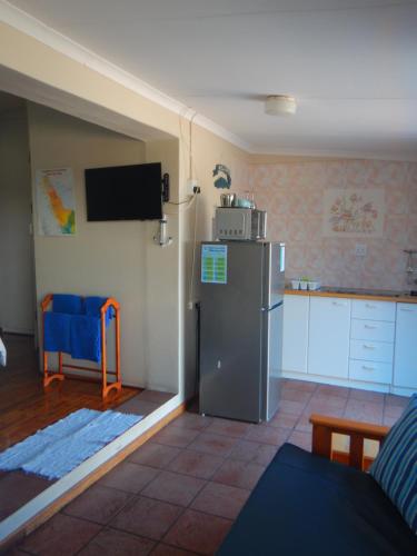 a kitchen with a refrigerator and a kitchen with a table at Thornbay accommodation in Doring Bay