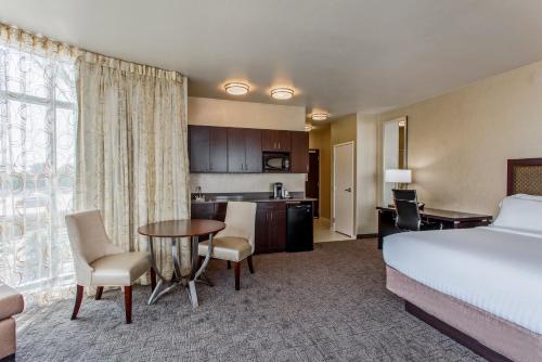 a hotel room with a bed and a table and a kitchen at Holiday Inn Express & Suites Anaheim Resort Area by IHG in Anaheim