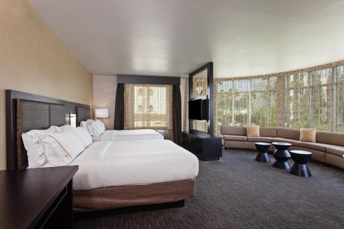 ein Hotelzimmer mit einem großen Bett und einer Couch in der Unterkunft Holiday Inn Express & Suites Anaheim Resort Area by IHG in Anaheim