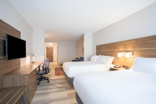a hotel room with two beds and a flat screen tv at Holiday Inn Express & Suites Owings Mills-Baltimore Area by IHG in Owings Mills