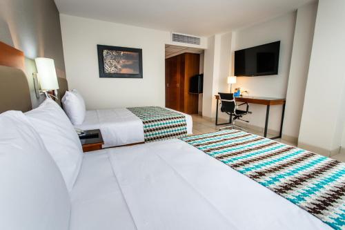 Habitación de hotel con 2 camas y escritorio en Costa del Sol Wyndham Pucallpa, en Pucallpa
