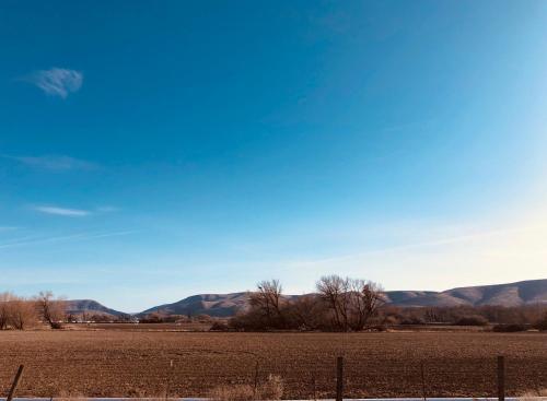 a field with a fence and mountains in the background at Days Inn by Wyndham Ellensburg in Ellensburg