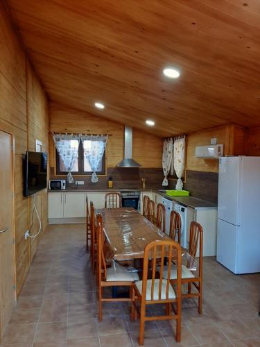 eine Küche mit einem Tisch und Stühlen sowie einem Kühlschrank in der Unterkunft Caseta De L'avi in Camarles