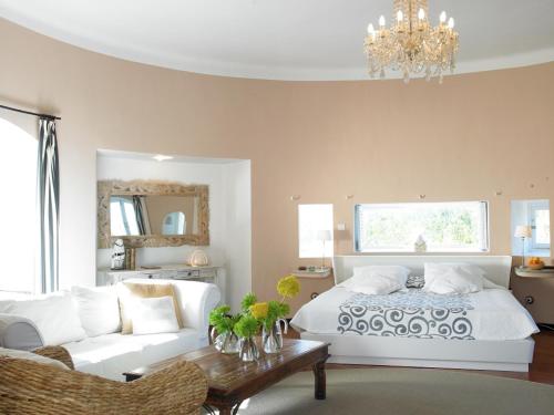 a bedroom with a bed and a couch and a chandelier at Agroturismo Can Talaias San CArlos in Sant Carles de Peralta