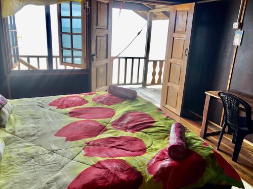 a bedroom with a large bed with a colorful blanket at Beachfront Hut Upstairs Astra - Beach Shack Chalet in Tioman Island