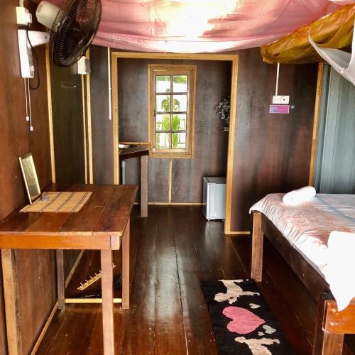 Habitación con escritorio, cama y ventana en Beachfront Hut Downstairs Astra - Beach Shack Chalet en Tioman Island