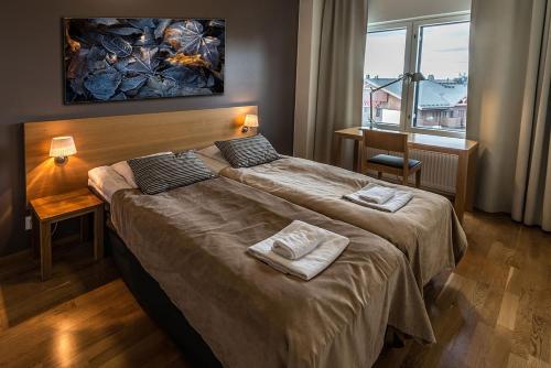 Cette chambre comprend 2 lits et une fenêtre. dans l'établissement Ruka Chalets Ski-Inn, à Ruka