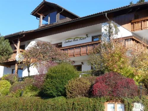 un bâtiment avec des arbres et des buissons devant lui dans l'établissement Landhaus Meine Auszeit, à Bodenmais