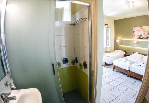 ein Bad mit einer Dusche und einem Waschbecken sowie ein Schlafzimmer in der Unterkunft Filoxenia in Tinos