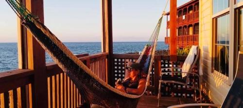 a woman is sitting in a hammock on a balcony at Lands End in West End
