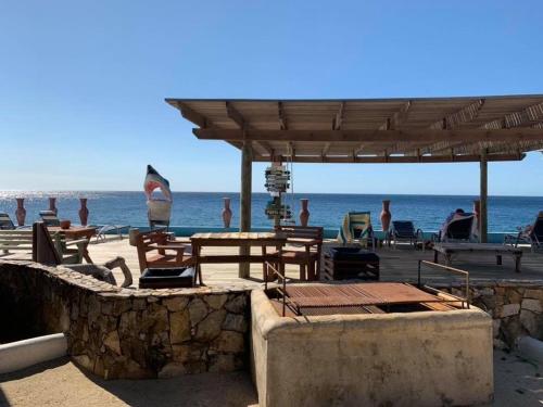 a beach with tables and chairs and the ocean at Lands End in West End