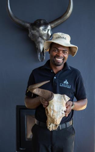 a man in a hat holding a skull and a horn at Cradle Boutique Hotel in Lanseria