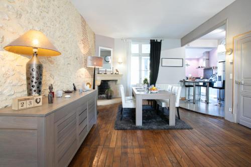 une cuisine avec une table et un salon dans l'établissement Maison de ville, à Périgueux