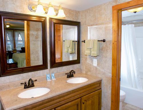 a bathroom with two sinks and a mirror at Myer Country Motel in Milford