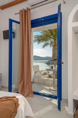 a bedroom with a blue door with a view of the ocean at Saint George Hotel in Naxos Chora
