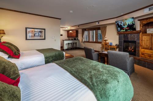 a hotel room with two beds and a fireplace at Lodge at Whitefish Lake in Whitefish