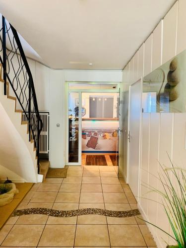 a hallway with white walls and a staircase at Aparthotel Kleine Perle in Cuxhaven