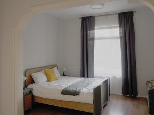 um quarto com uma cama e uma grande janela em Caché ✦ Bright One-Bedroom Apartment in Sofia em Sófia