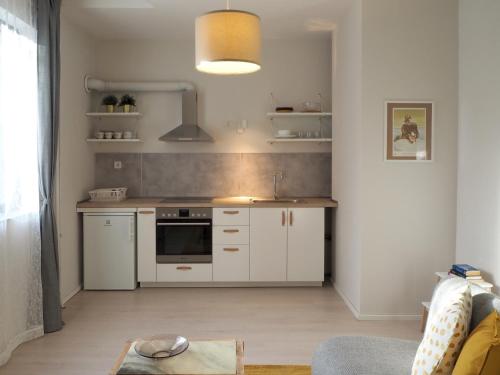 uma cozinha com armários brancos e um lavatório em Caché ✦ Bright One-Bedroom Apartment in Sofia em Sófia
