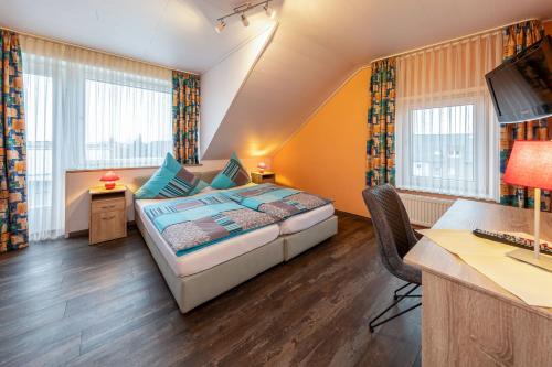 1 dormitorio con 1 cama y escritorio con ordenador en Gasthof zum Siegburger, en Straelen