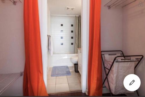 an orange shower curtain in a bathroom with a toilet at Vancouver Downtown Central 1 bedroom Condo in Vancouver