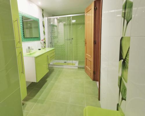 y baño con ducha, lavabo y espejo. en Neptuno Apartment: Sun, beach and relax in Huelin, en Málaga