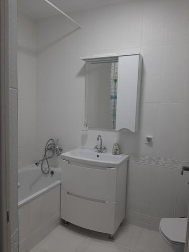 Baño blanco con lavabo y espejo en Люкс 2 en Úzhgorod