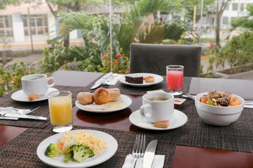 una mesa con platos de comida y tazas de café en Wyndham Costa del Sol Pucallpa, en Pucallpa
