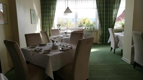 uma sala de jantar com uma mesa e cadeiras e uma janela em Hotel Landhaus Lahmann em Bad Eilsen