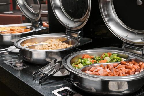 Un montón de ollas de comida en una estufa en Wyndham Costa del Sol Pucallpa, en Pucallpa
