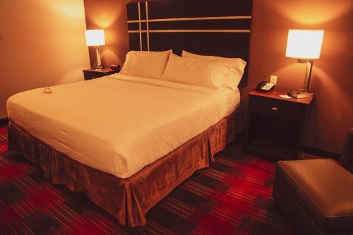 a hotel room with a large bed with two lamps at Holiday Inn Express & Suites Cumberland - La Vale by IHG in La Vale