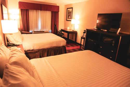 a hotel room with two beds and a flat screen tv at Holiday Inn Express & Suites Cumberland - La Vale by IHG in La Vale